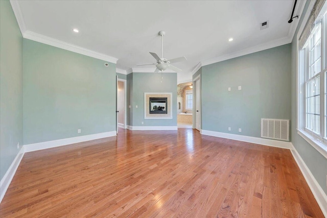 unfurnished living room featuring a wealth of natural light, visible vents, and a ceiling fan
