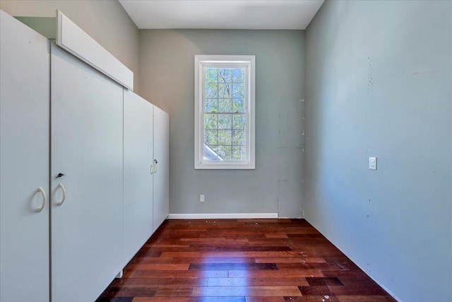 unfurnished bedroom featuring dark wood-style floors and a closet
