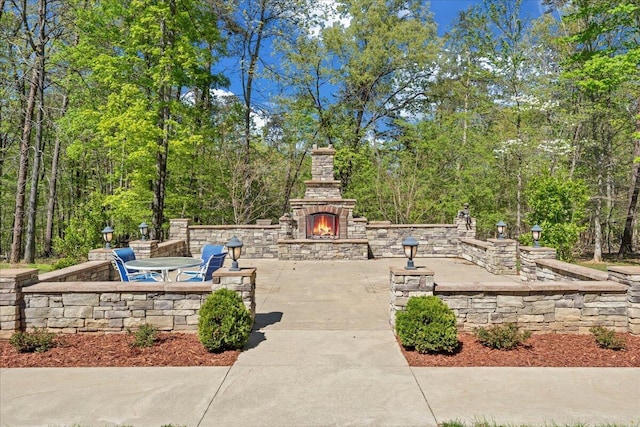 view of patio / terrace featuring an outdoor stone fireplace
