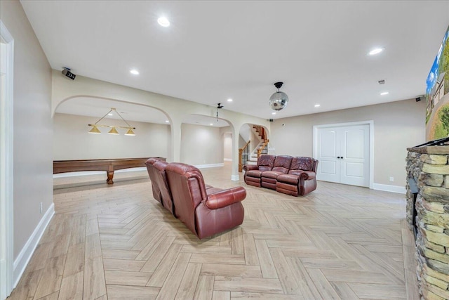 living area with recessed lighting, arched walkways, stairs, baseboards, and visible vents