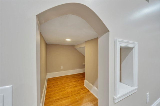 corridor with baseboards and light wood-type flooring