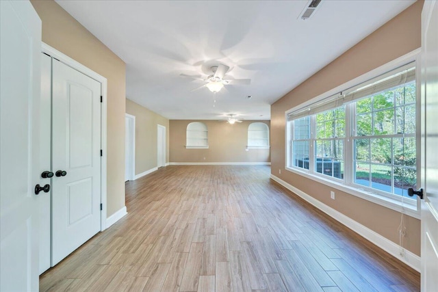 unfurnished room with visible vents, ceiling fan, light wood finished floors, and baseboards