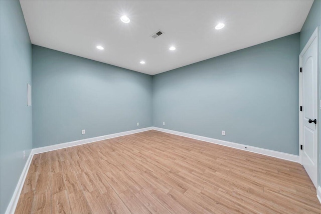 empty room featuring light wood-style floors, recessed lighting, visible vents, and baseboards
