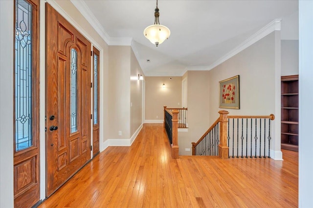 foyer entrance with ornamental molding, light wood-style flooring, and baseboards
