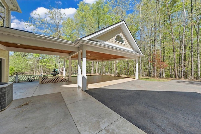 view of patio with a carport, central AC unit, and aphalt driveway