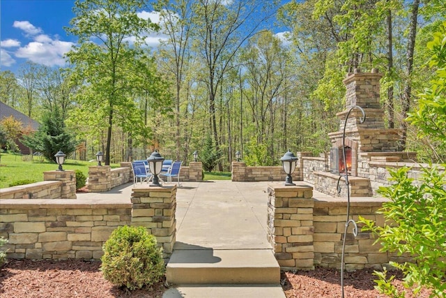 view of patio with an outdoor stone fireplace