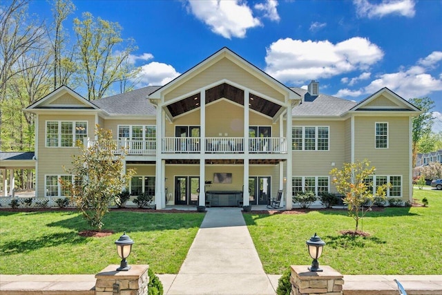 view of front facade with roof with shingles, a chimney, french doors, and a front lawn