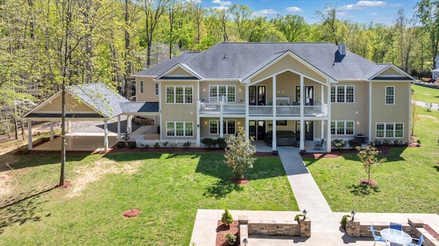 rear view of property with a patio, central AC, a yard, and roof with shingles