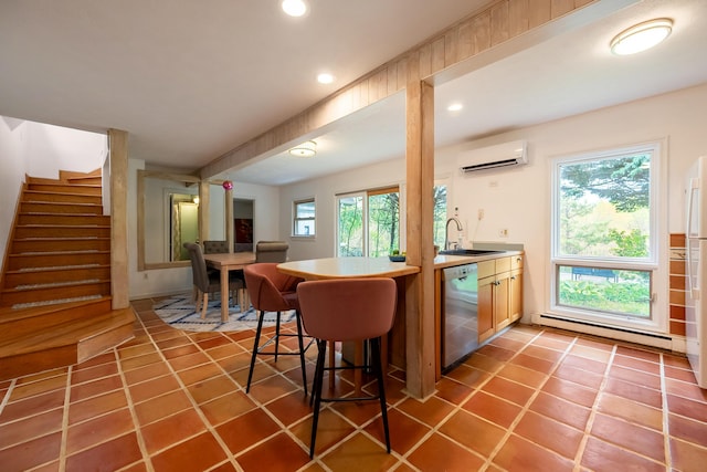 kitchen featuring recessed lighting, stainless steel dishwasher, a wall mounted AC, baseboard heating, and a sink