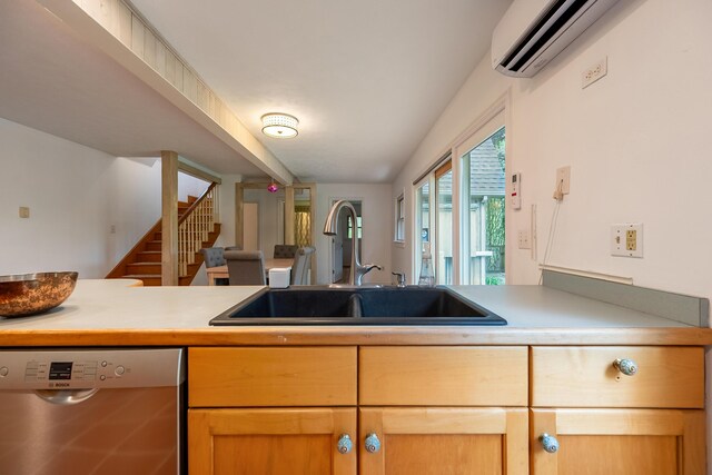 kitchen featuring stainless steel dishwasher, a sink, a wall mounted air conditioner, and light countertops