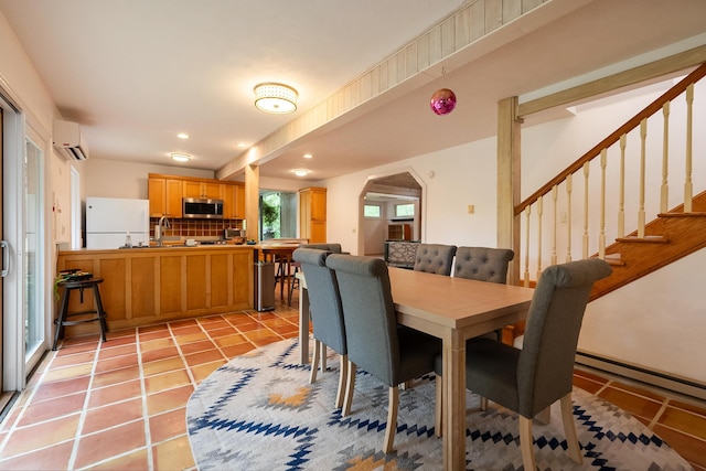 dining space with light tile patterned floors, arched walkways, recessed lighting, a wall mounted air conditioner, and stairs