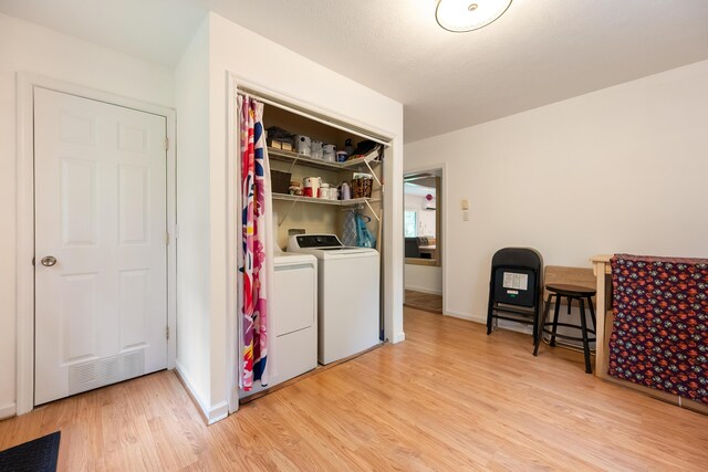 laundry room featuring light wood finished floors, laundry area, visible vents, baseboards, and washer and dryer