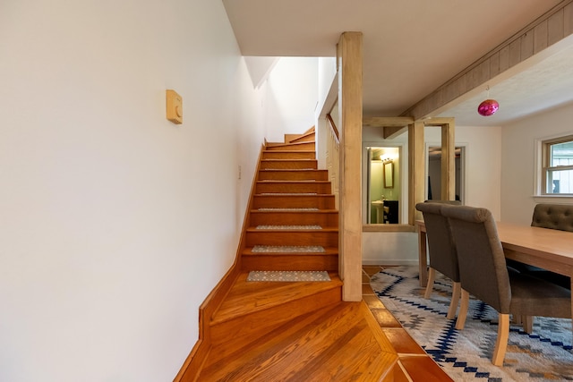 staircase featuring wood finished floors and baseboards