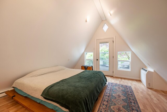 bedroom featuring light wood-style flooring, baseboard heating, access to exterior, and vaulted ceiling with beams