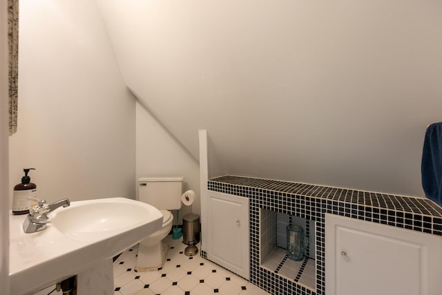 bathroom with toilet and lofted ceiling