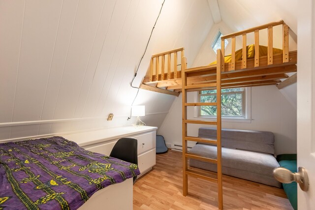 bedroom featuring vaulted ceiling with beams, a baseboard heating unit, and light wood finished floors