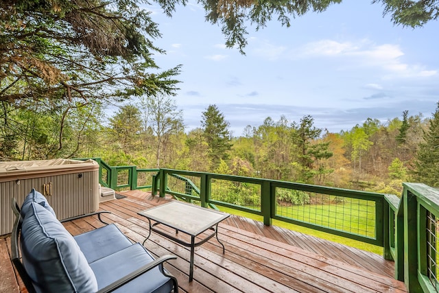 wooden deck featuring a view of trees and a hot tub