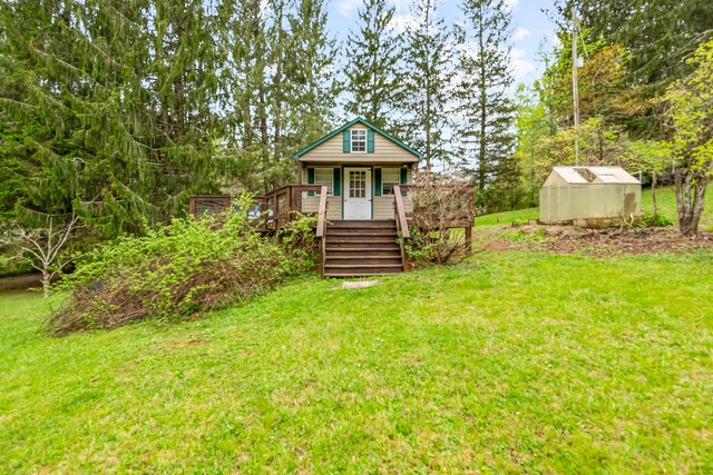 view of front of property with a deck, a front lawn, an outdoor structure, and an exterior structure