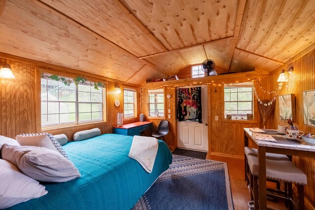 bedroom featuring lofted ceiling, wooden walls, wood finished floors, and wood ceiling