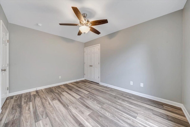 unfurnished room featuring baseboards, ceiling fan, and light wood-style flooring