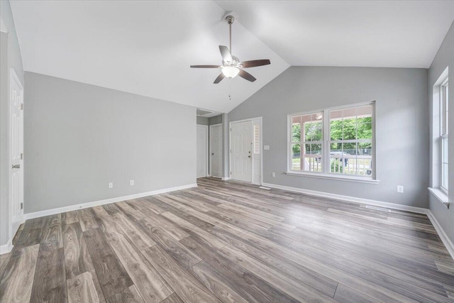unfurnished bedroom with baseboards, ceiling fan, vaulted ceiling, and wood finished floors