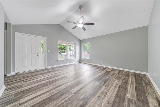 unfurnished living room with baseboards, ceiling fan, vaulted ceiling, and wood finished floors