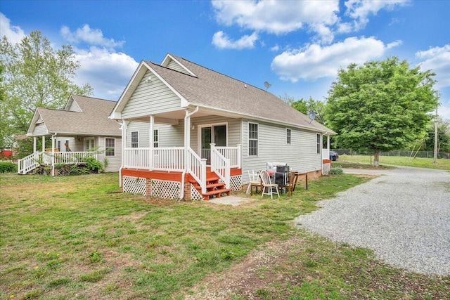 back of house with roof with shingles, fence, and a yard