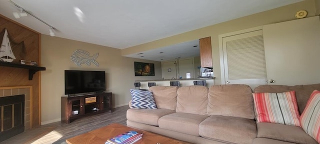 100 Sailors Cove Dr Unit 1319, Moneta, VA 24121 - living area featuring rail lighting, wood finished floors, a tiled fireplace, and baseboards