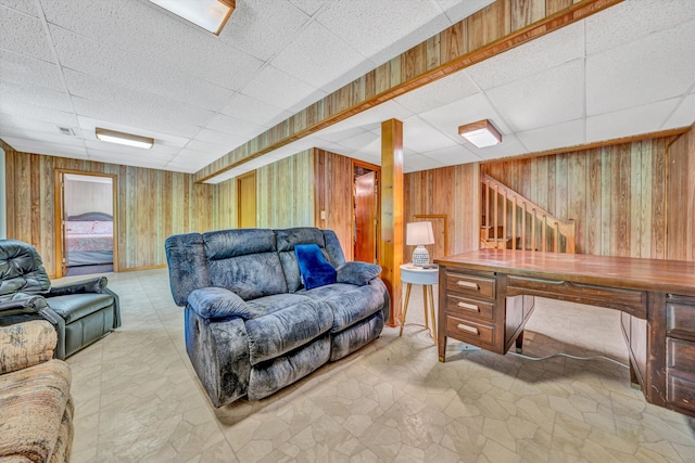 living room with wood walls, stairway, visible vents, and a paneled ceiling