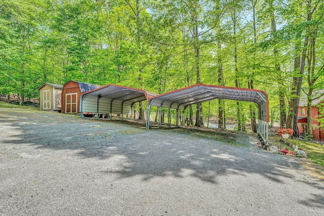 view of vehicle parking with a carport, driveway, and a storage shed
