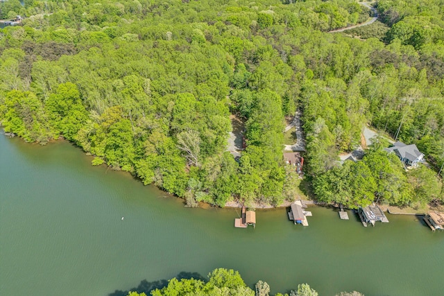 drone / aerial view featuring a wooded view and a water view