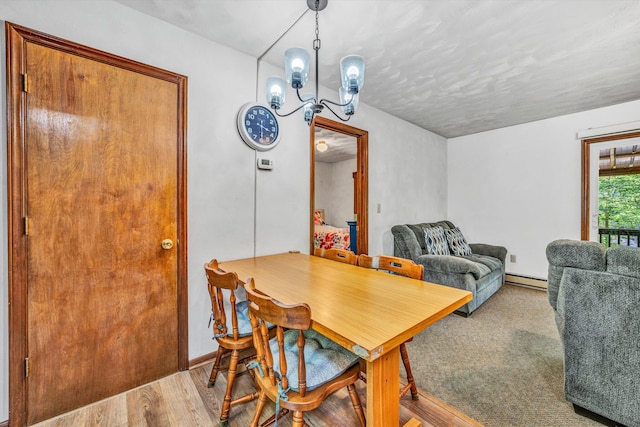 dining area with a notable chandelier, wood finished floors, and a baseboard radiator