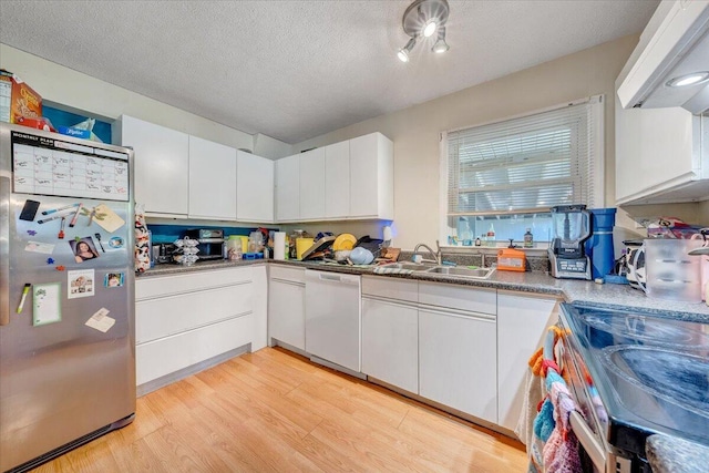 712 Baltimore Ave, Bedford, VA 24523 - kitchen featuring appliances with stainless steel finishes, a sink, light wood finished floors, white cabinets, and a textured ceiling