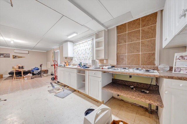 712 Baltimore Ave, Bedford, VA 24523 - kitchen with open shelves, white cabinets, an AC wall unit, and light countertops