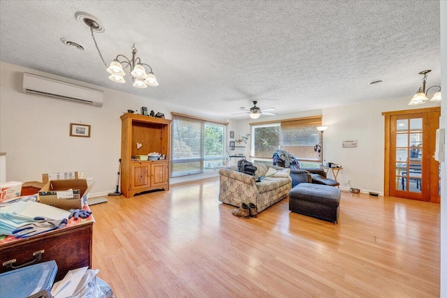 712 Baltimore Ave, Bedford, VA 24523 - living area with a wall mounted air conditioner, a textured ceiling, light wood-style floors, a chandelier, and a ceiling fan