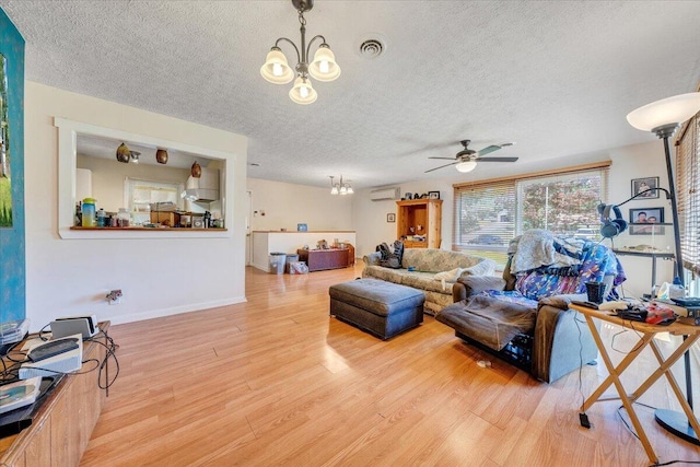 712 Baltimore Ave, Bedford, VA 24523 - living room featuring a chandelier, a textured ceiling, an AC wall unit, and light wood-type flooring