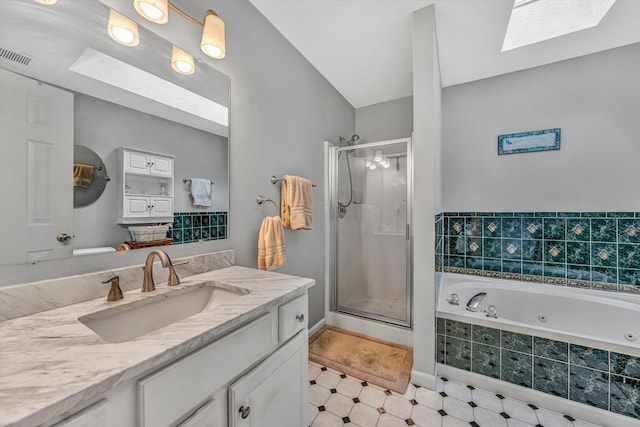 full bathroom featuring visible vents, vanity, a whirlpool tub, a shower stall, and a skylight