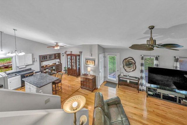 living room featuring a ceiling fan, light wood-style flooring, and lofted ceiling
