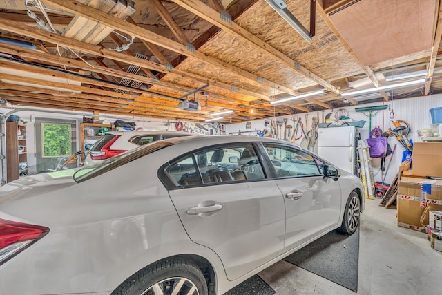 garage featuring a garage door opener and freestanding refrigerator