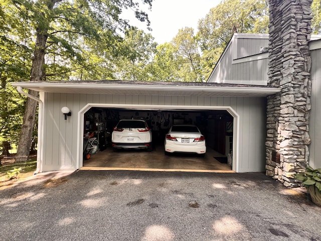 view of parking with a garage and aphalt driveway
