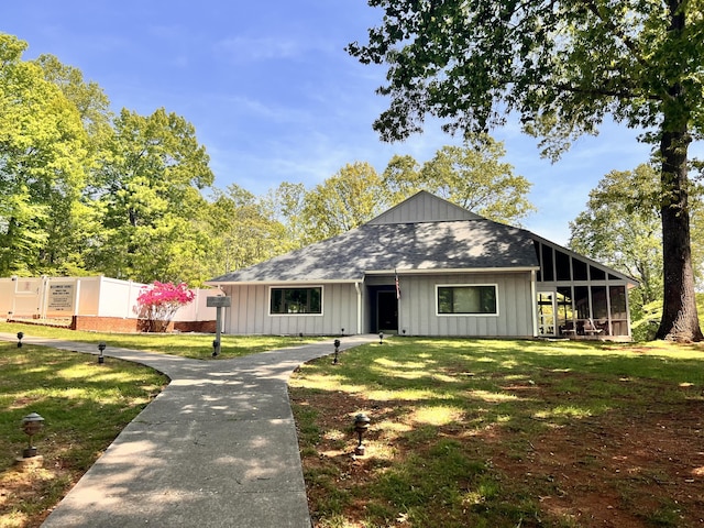 bungalow featuring a shingled roof, board and batten siding, and a front lawn