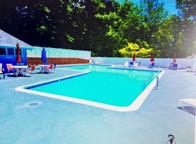 pool featuring fence and a patio
