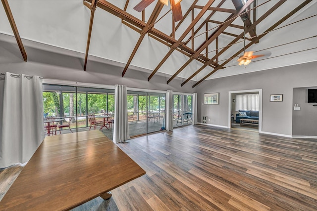 unfurnished living room featuring high vaulted ceiling, baseboards, ceiling fan, and wood finished floors