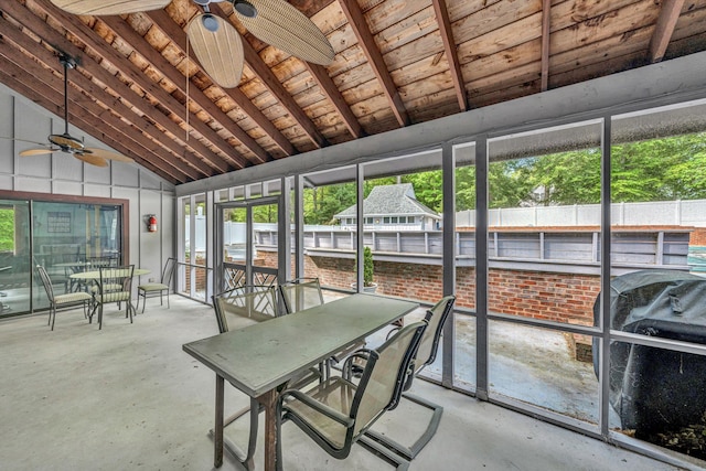 sunroom / solarium featuring outdoor dining area, ceiling fan, and beamed ceiling