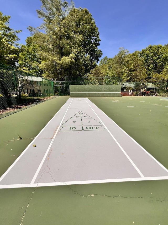 view of home's community featuring fence and shuffleboard