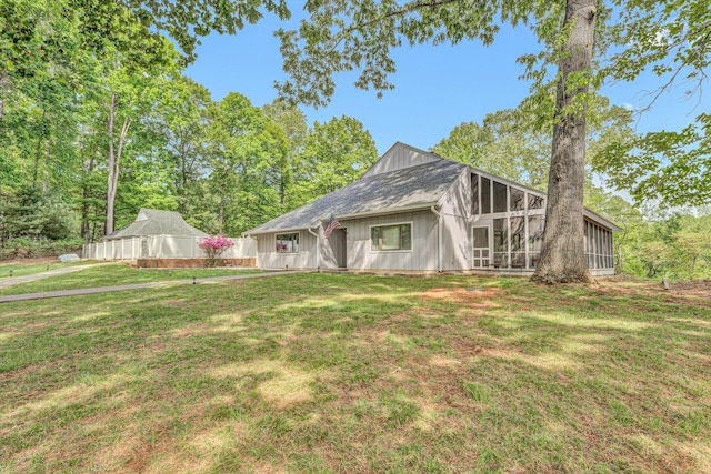 rear view of property featuring a sunroom, board and batten siding, and a yard
