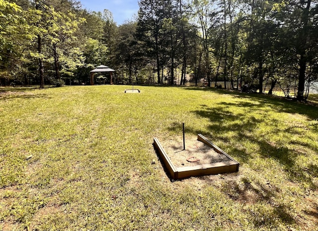 view of yard featuring a view of trees and a gazebo