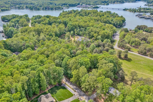 drone / aerial view featuring a water view and a forest view