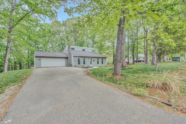 view of front of property with roof with shingles, a garage, a front yard, and aphalt driveway
