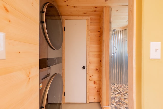washroom featuring stacked washer and clothes dryer and laundry area